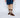 Person wearing brown leather shoes and patterned socks on a white background