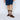 Person wearing brown leather shoes and patterned socks on a white background